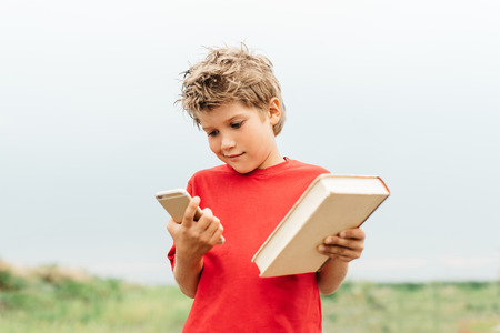 The guy chooses between a book and a smartphoneの写真素材