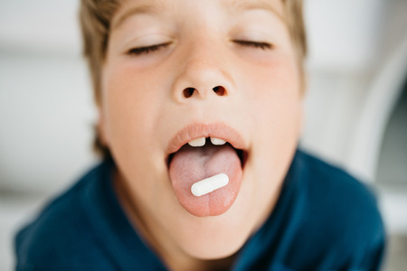 The boy holds the tablet on the tongueの写真素材