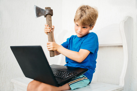 A boy with an ax and a laptopの写真素材