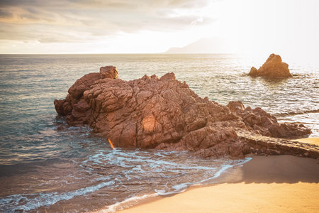 Seaside red rocks with sunsetの写真素材