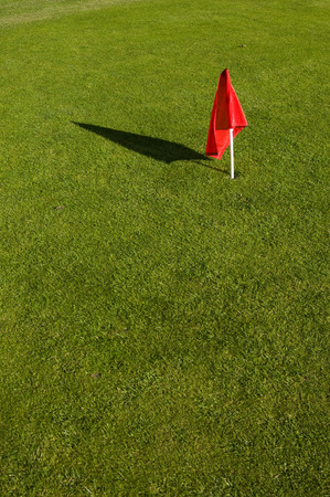 red flag on green grassの写真素材