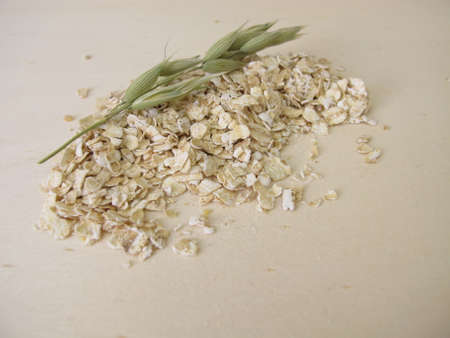 Fine rolled oats flakes on a wooden boardの写真素材