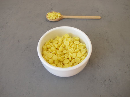A bowl of light yellow cocoa butter chips as an ingredient for cooking and baking, chocolate making or personal care productsの写真素材