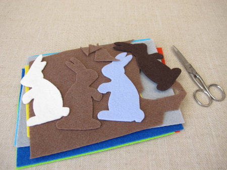 Easter bunnies cut out of colorful felt with scissorsの写真素材