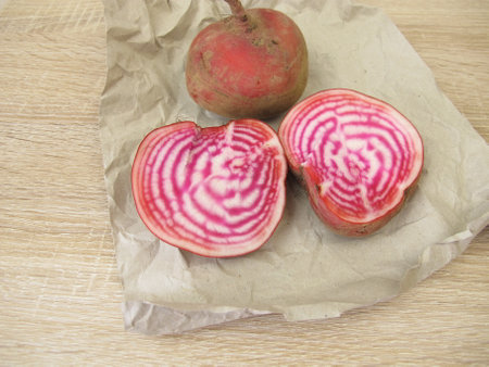 A whole and a halved Chioggia beetroot on paperの写真素材