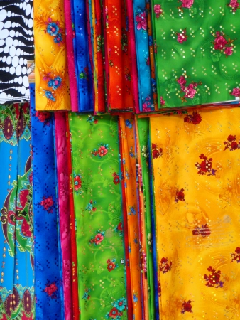 Sheets of brightly colored fabrics, folded and hanging on racks  Shot in Egypt         の写真素材