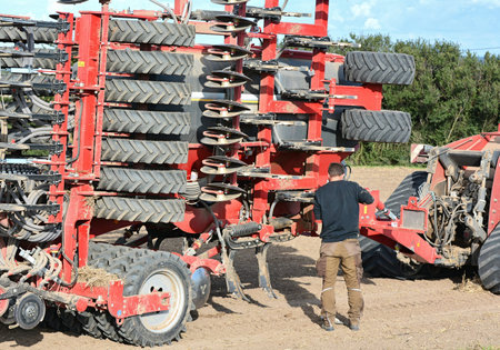 BASTORF, GERMANY - AUGUST 26, 2014: a farmer during the repair of a machine on the fieldのeditorial素材