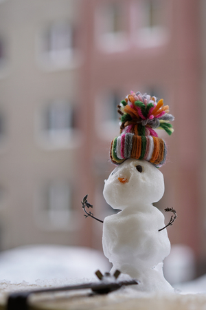 Snowman in winter on a balcony railingの写真素材