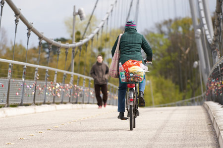 MAGDEBURG, GERMANY - April 22, 2017: cyclist and pedestrian on a suspension bridge over the river Elbe in Magdeburg. The bridge which built in 1999 on the occasion of the Federal Garden Show in Magdeburgのeditorial素材