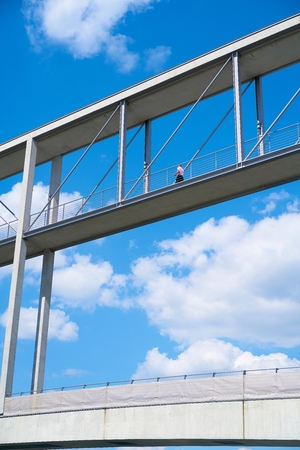 BERLIN, GERMANY - AUGUST 07, 2017: Man on a bridge between two government buildings in the government quarter in Berlinのeditorial素材