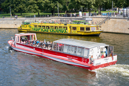 BERLIN, GERMANY - AUGUST 07, 2017: Excursion boats on the River Spree in Berlin. Many tourists take the opportunity to explore the city from the riverのeditorial素材