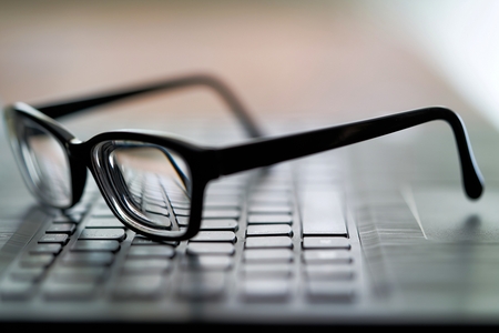 blurred illustration of a glasses on a computer keyboardの写真素材