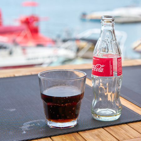 VRSAR, CROATIA - JULY 21, 2018: Coca-Cola bottle and a glass on the table at the bar in the city of Vrsar in Croatiaのeditorial素材