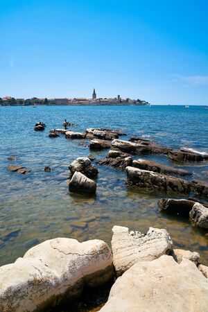 View from the rocky coast near Porec to the old townの写真素材