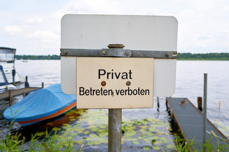 Sign with the inscription Privat, no trespassing on the banks of the River Havel near Werder in Germanyの写真素材