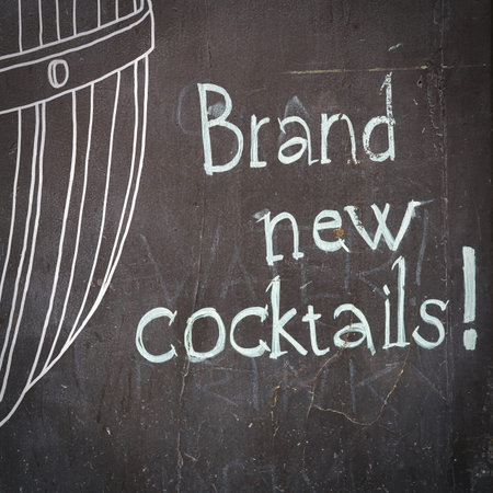Slate board in front of a cocktail bar in Prague with the inscription brand news Cocktails