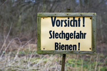 Sign at the edge of the forest in Germany with the inscription Caution Danger of stinging bees