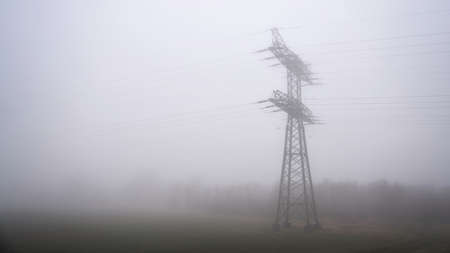 Power pole on a field near Magdeburg in Germany in fogの写真素材