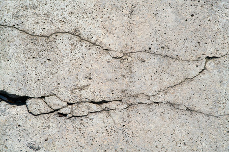 Close up of cracks in a dilapidated concrete wall on a building