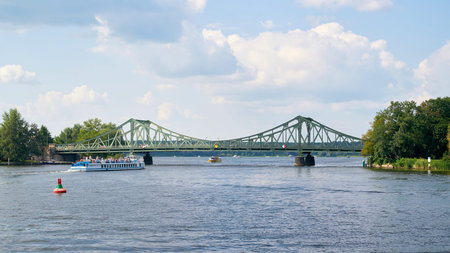 Berlin, Germany - July 17, 2021: The Glienicke Bridge over the Havel River between Potsdam and Berlin. In the foreground an excursion boat with tourists.のeditorial素材