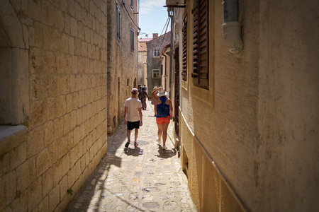 Krk, Croatia - August 10, 2021: Tourists in a narrow alley in the old town of Krk on the island of...