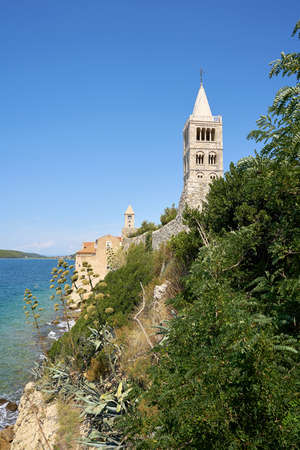 Bell tower of the Cathedral of the Assumption of the Blessed Virgin Mary from the 12th century on the coast of the town of Rab on the Adriatic Sea in Croatiaの写真素材