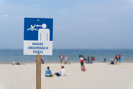 Sign on the beach of the Baltic Sea near Kolobrzeg with the inscription Order to observe children (Nakaz Obserwacji Dzieci)の写真素材