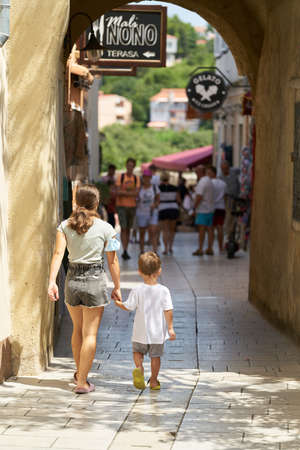Krk, Croatia â August 06, 2021: Holidaymakers in an alley in the historic old town of Krk on the island of the same name in Croatiaのeditorial素材