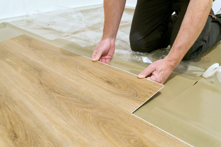 Craftsman renovating an apartment and laying a click vinyl floor covering