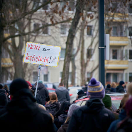 Magdeburg, Germany â January 08, 2022: Demonstration of Corona deniers and vaccination opponents in the city center of Magdeburg. Translation on the sign: no to compulsory vaccinationのeditorial素材