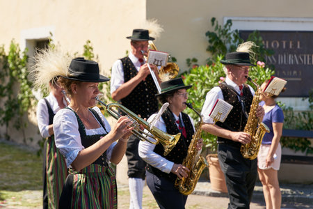 Duernstein, Austria â June 16, 2022: Members of the brass band DÃ¼rnstein in traditional costumes during a procession on Corpus Christi in front of the castle in DÃ¼rnsteinのeditorial素材