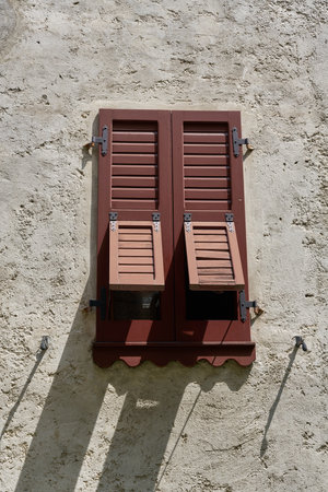 Shutter on the facade of an old residential building in the old town of Limone Sul Garda on Lake Garda in Italyの写真素材