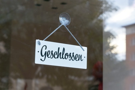 Sign with German inscription Closed on a dirty shop window in the city center of Magdeburg in...