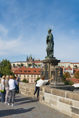 Prague, Czech Republic â October 02, 2023: Tourists in front of the statue of St. Nepomuk on the Charles Bridge in Pragueのeditorial素材