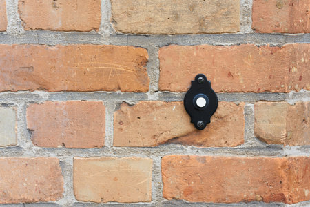 Doorbell button on a brick wall in the old town of Bruges in Belgium