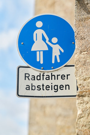 Sign in a pedestrian zone with the German inscription Radfahrer absteigen. Translation: cyclists dismountの写真素材