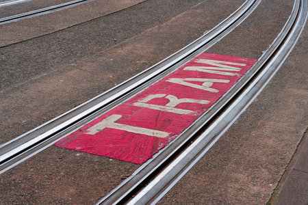 Indication of danger by the moving coastal streetcar, Kusttram by the striking lettering Tram in the city center of Blankenberge in Belgiumの写真素材