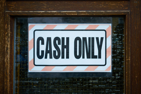Sign on the entrance door to a store with the words Cash Onlyの写真素材