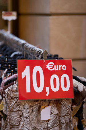 Red sign with the inscription 10.00 euros indicating a special offer on clothingの写真素材