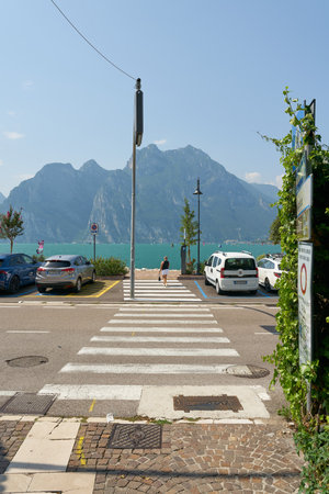 Torbole sul Garda, Italy â August 14, 2025: Crosswalk leading to the waterfront promenade of Torbole Sul Garda on Lake Garda in Italy. In the background, Monte Cima Giochelloのeditorial素材