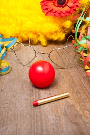 Utensils of a clown costume laying on a wooden boardの写真素材
