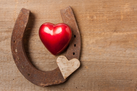 Red heart and a horseshoe on a wooden boardの写真素材