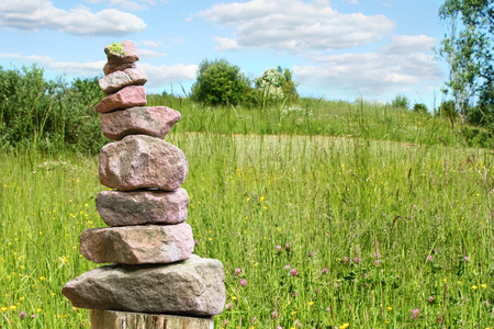 Stacked stone pyramid from sandstone as a sign for awareness on a juicy meadowの写真素材