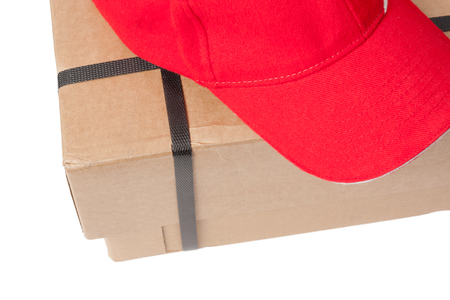 Parcel with a postmans hat lying on top, isolated on white backgroundの写真素材
