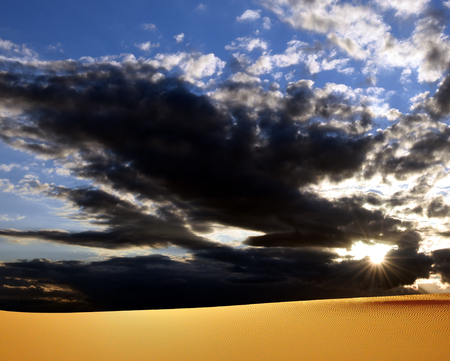 desert in the Middle East under a cloudy sunset skyの写真素材