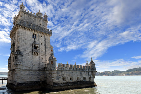 Scenic Belem tower and wooden bridge mirco with low tides on Tagus River. Torre de Belem is Lisbon's...