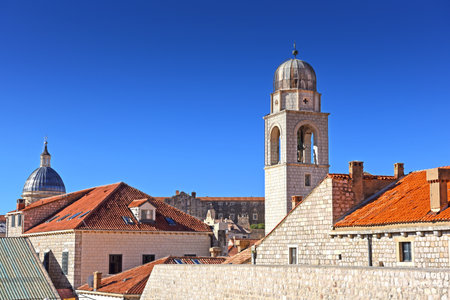 slim tower above the Dominican Monastery with classic red tiled rooftops inside the old town of Dubrovnik, Croatiaの写真素材