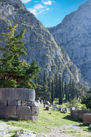 View to the ruins and the sacred way leading to the treasury of the Athenians in Archaeological Site...