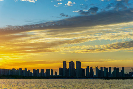 Sunset over the sea with dramatic sky and skyscrapers.の写真素材