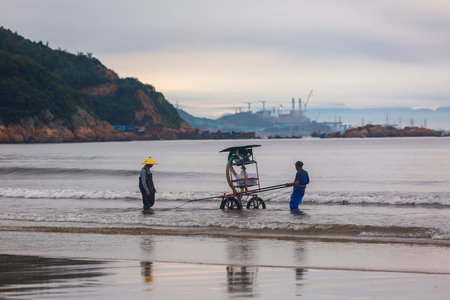 Fishermen are working on the beach in the early morning.の写真素材